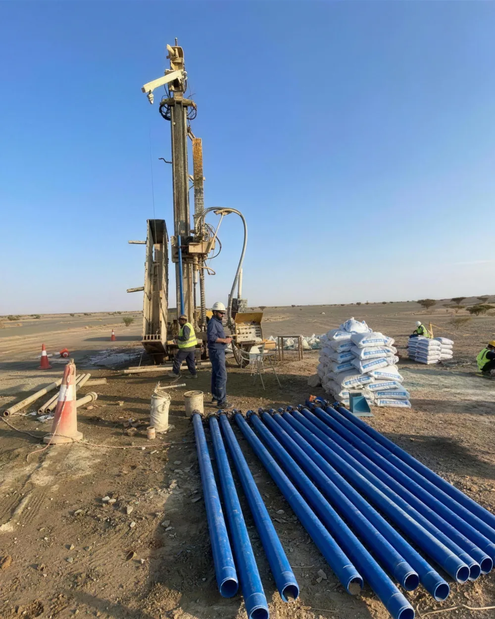 Drilling rig with blue well casing laid out on site