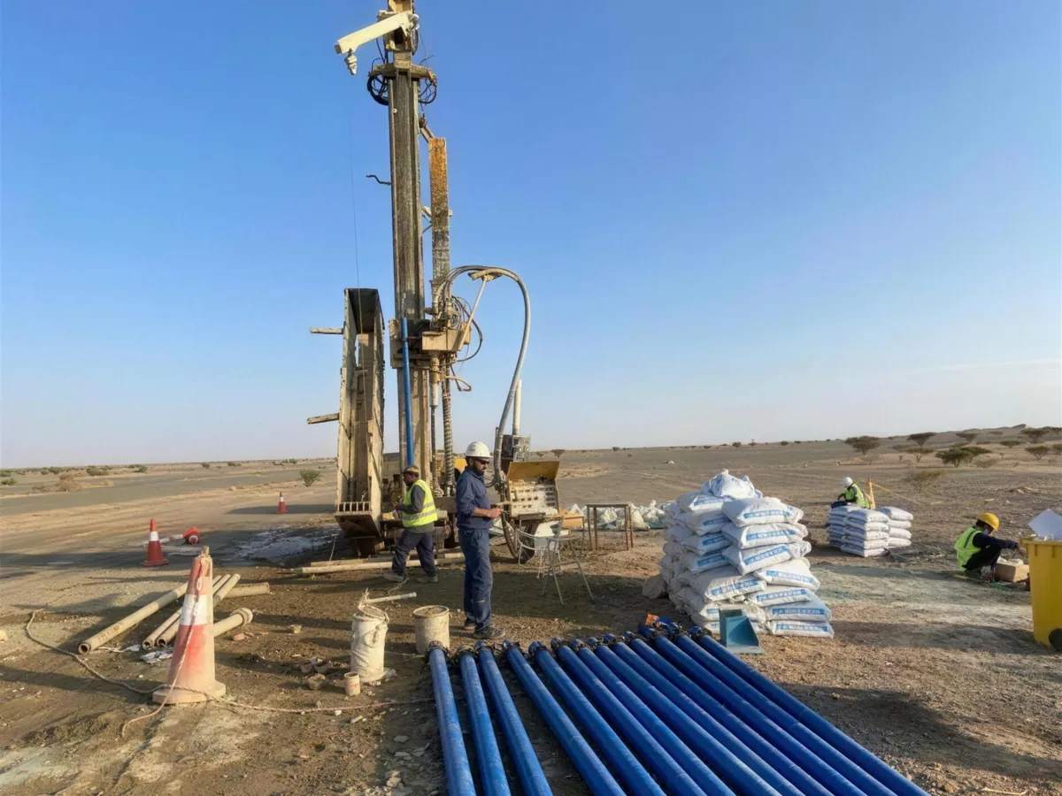 Drilling rig with blue well casing laid out on site